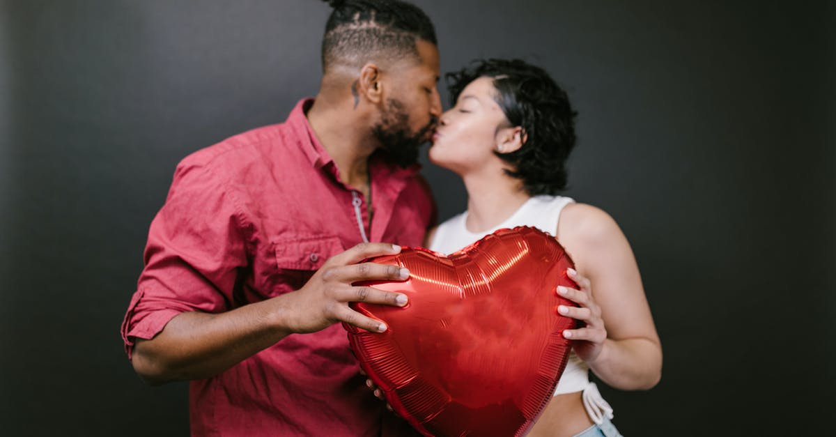 B2 Visa for my Employee/Partner - Couple Kissing While Holding a Red Heart Shaped Balloon