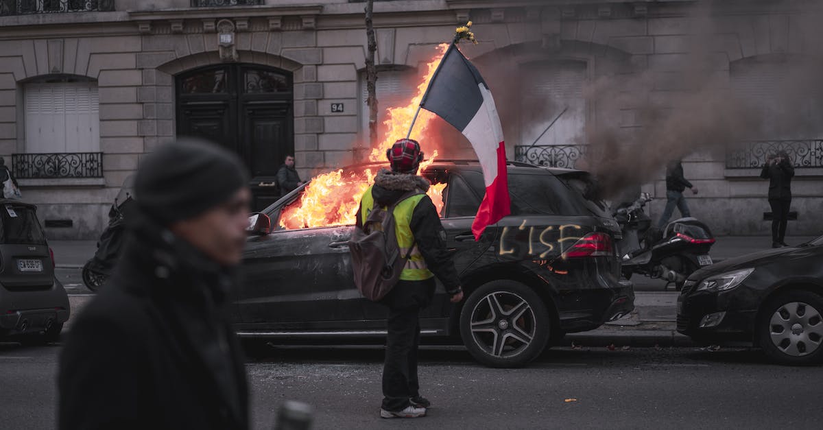 Backpack in France [closed] - Man in Black Jacket Holding Red and Yellow Umbrella