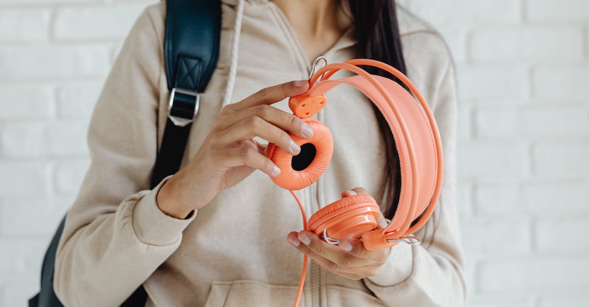 Backpack in France [closed] - Woman in White Blazer Holding Orange Plastic Headphones