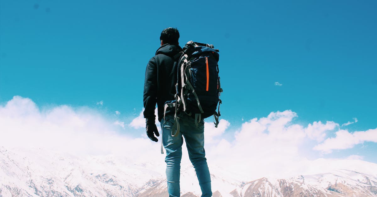 Backpacking - travelling with 'smart' clothes - Photo of Man Standing On Top Of Mountain