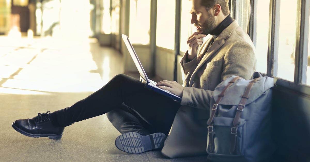 Bag wrapping at airports in USA - Brown Haired Man Using Laptop Computer