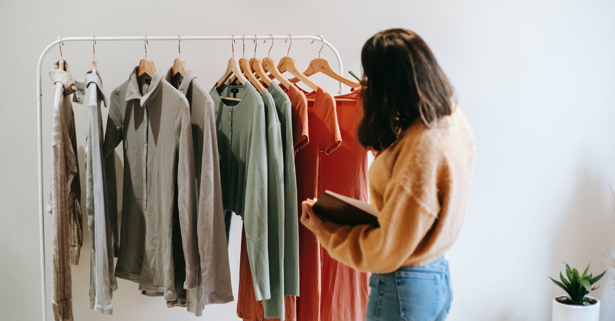 Baggage and check-ins on different airlines - Faceless female seller with notepad near clothes on hangers