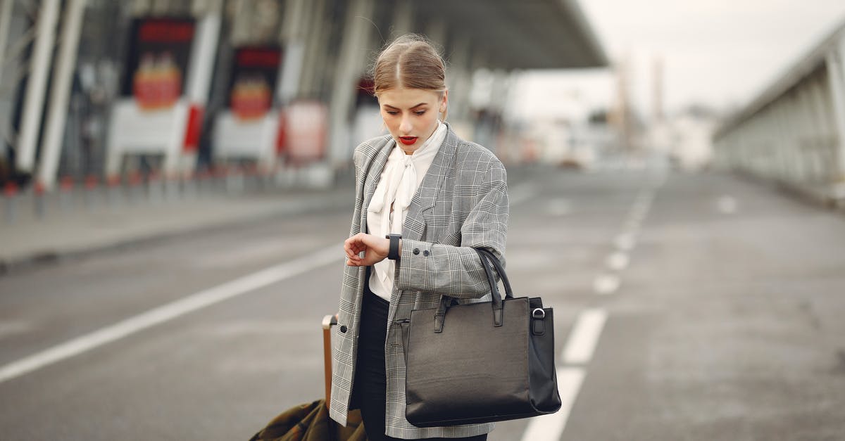 Baggage checked? - Worried young businesswoman with suitcase hurrying on flight on urban background