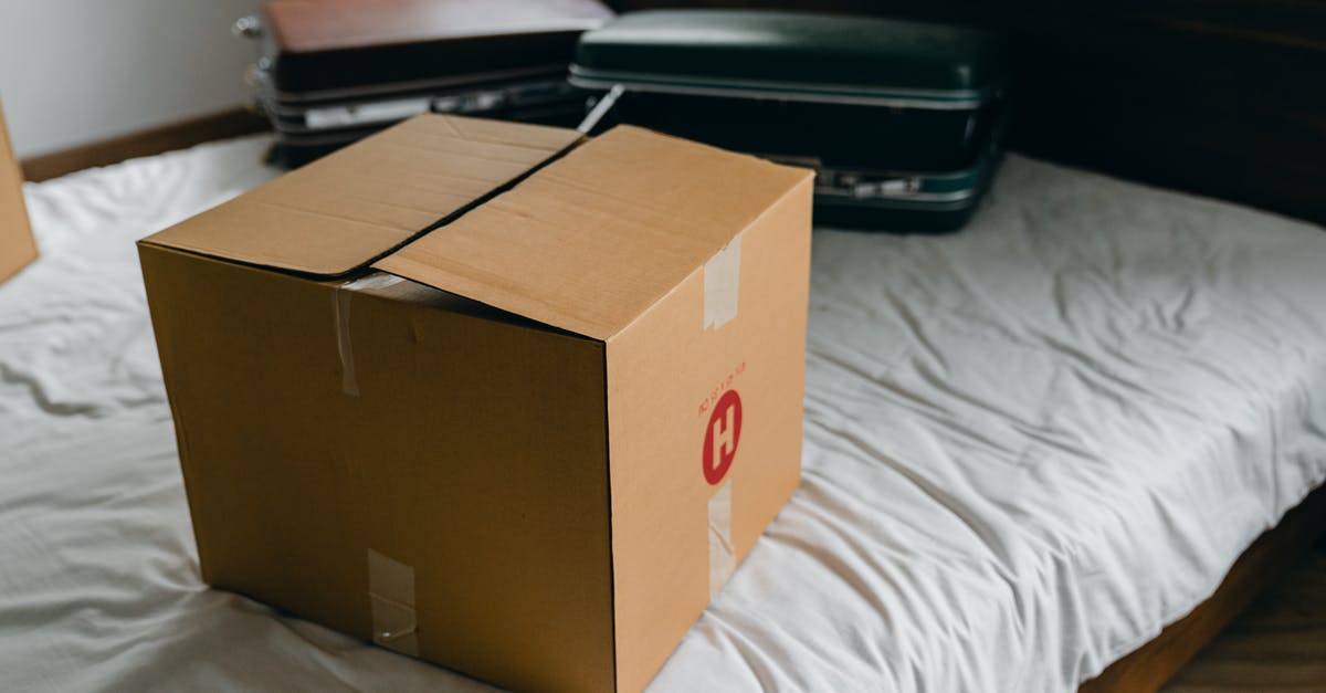 Baggage claim during changing flights - Carton box and suitcases for relocation on bed