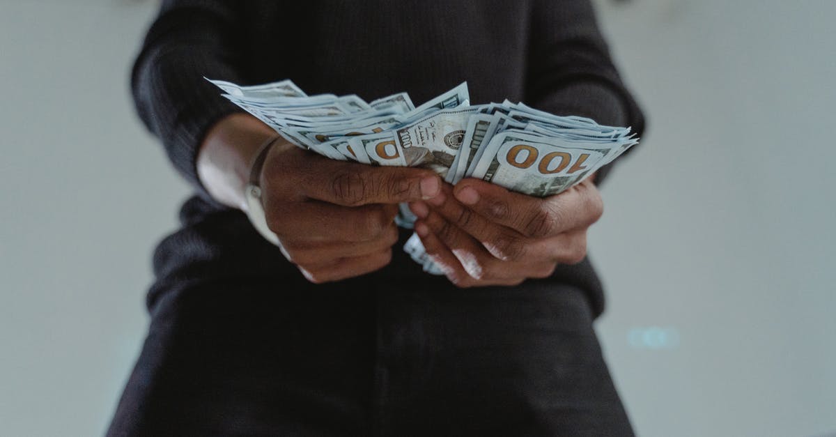 Bank Balance required for Schengen Visa - Close-Up Photo of a Person's Hands Holding Dollar Bank Notes