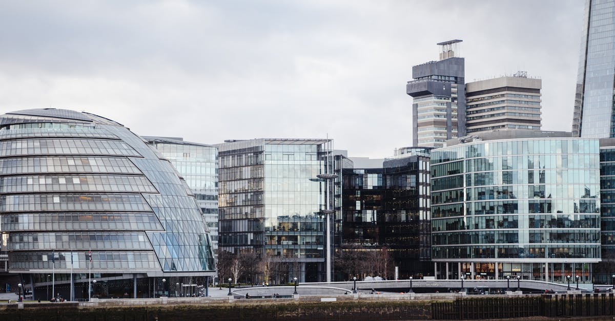 Bank statement for UK visa - Contemporary buildings with glass walls located on street in financial district on embankment near calm Thames river in modern city