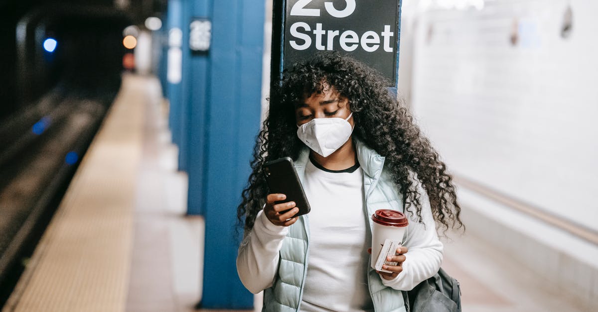 Barbados via JFK - Transit on Media Visa - Focused black woman using smartphone on metro platform