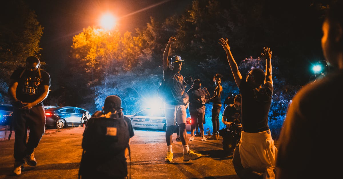 Being a tourist, can I film police in the US? - Black men standing on street near journalists and police car during anti racism demonstration