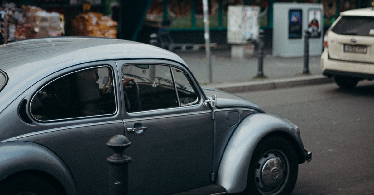 Berlin to Auschwitz by car - Silver Volkswagen Beetle Parked on Sidewalk