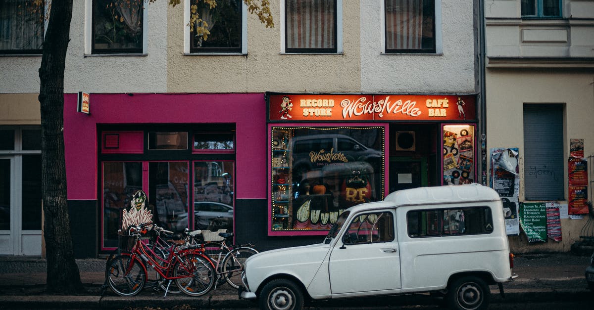 Berlin to Auschwitz by car - White 5 Door Hatchback Parked Beside Red and Black Bicycles