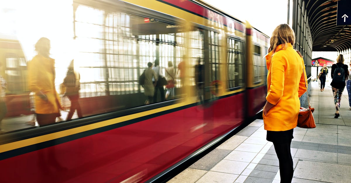 Berlin to Göttingen by train - which Berlin station to use? - Woman Standing Beside Red Train