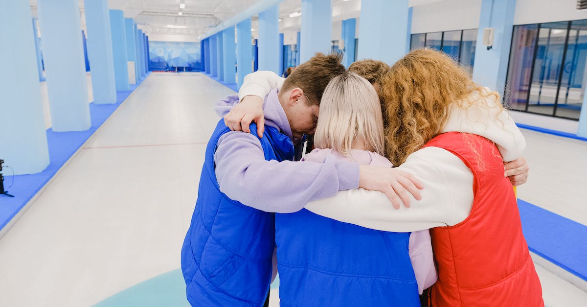 Best company for flying from Europe to Australia [closed] - High angle of anonymous team embracing each other while standing in spacious light gym