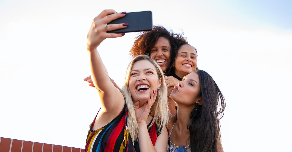 Best phone provider for a three-month visit to Thailand? [duplicate] - Cheerful multiethnic girlfriends taking selfie on smartphone on sunny day