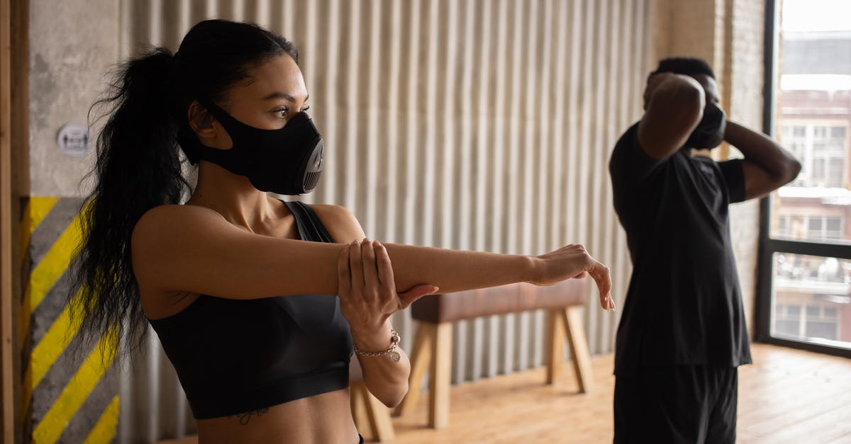 Best practice for managing Covid vaccination documentation - Black sportspeople in fabric masks warming up in gym