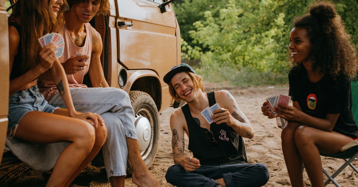 Best transportation option for living 4 months in Vienna? - Friends Playing a Card Game outside Their Camper Van