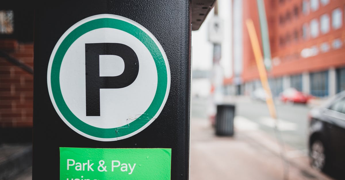 Best way to pay in Poland when I have Euros? - Green sticker for paid parking by phone on black parking meter located on sidewalk near road with cars in city