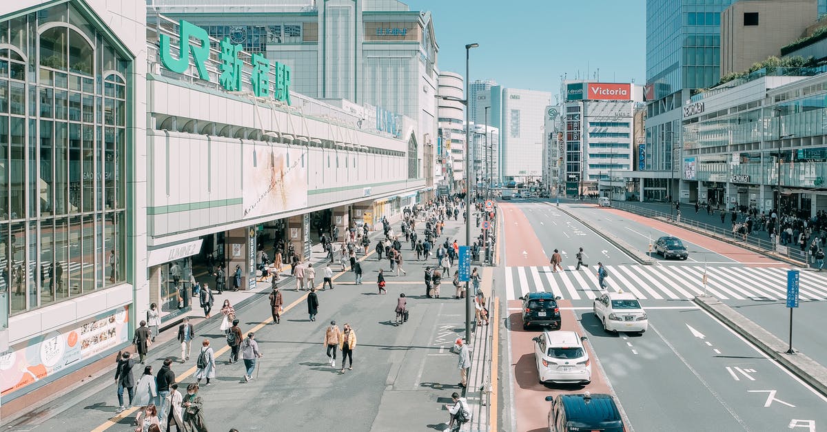 Best way to travel from Palenque to Mexico city by road - From above of unrecognizable people walking near road and modern Shinjuku Station located against cloudless blue sky in Tokyo