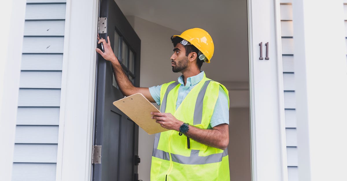 Best website for checking PNR status for Indian Railways - A Man in Safety Vest and Hard Hat Checking the Front Door