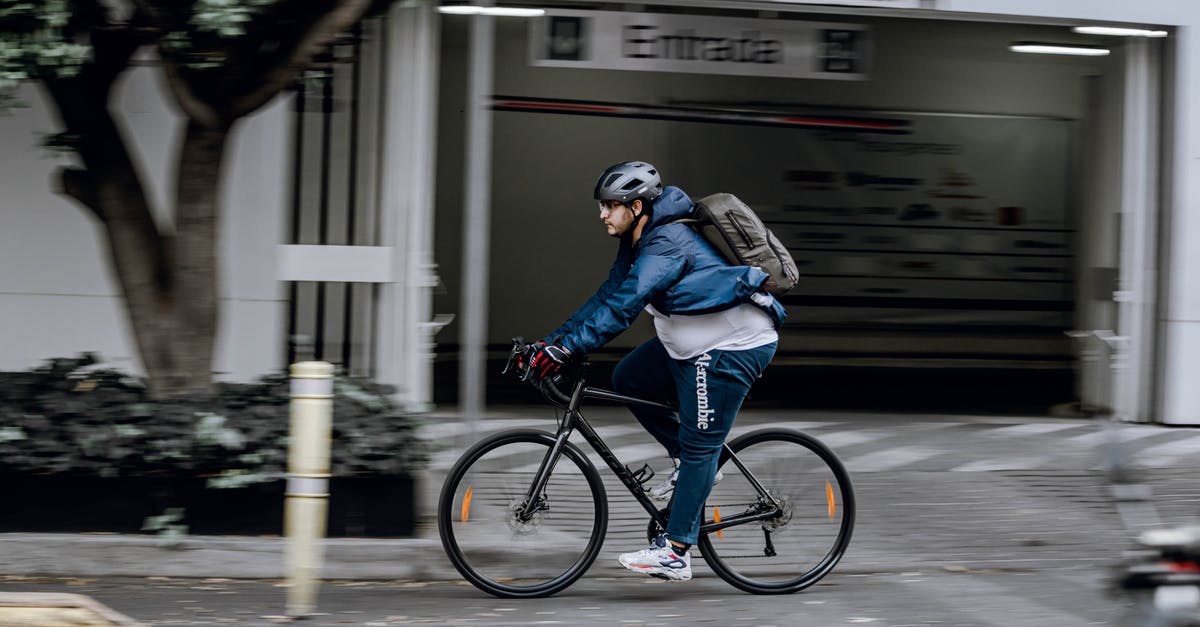 Bicycle helmet and backpack as carry-on in the US? - Man in Black Jacket Riding on Black Bicycle