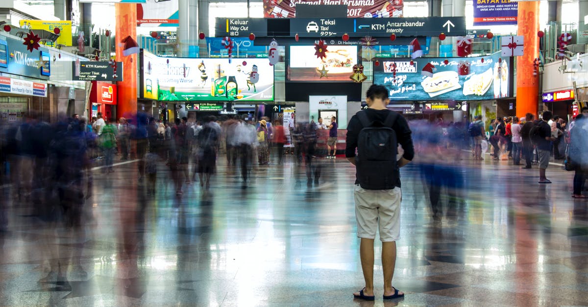 Board Chinese train at a different station (on-route) - Man in Black Jacket and Beige Pants Walking on Gray Floor Tiles