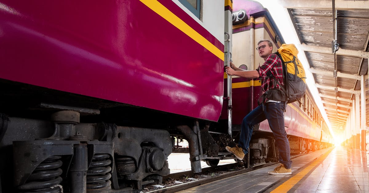 Board Chinese train at a different station (on-route) - Man With Yellow and Black Backpack Standing Near Train