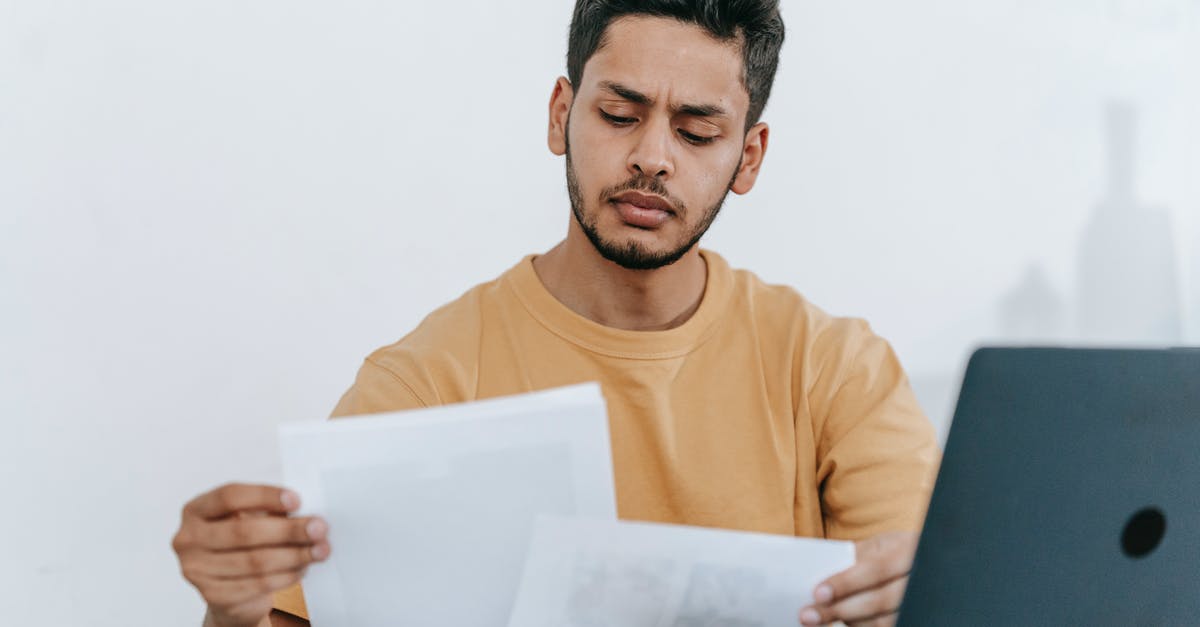 Boarding passes and online check-in - Man looking through documents at workplace