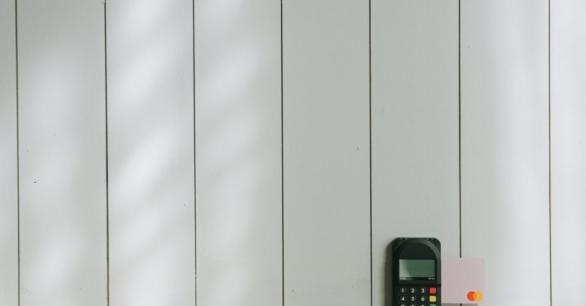 Booking guarantee with an empty debit card - Black and Gray Digital Device on Brown Wooden Table