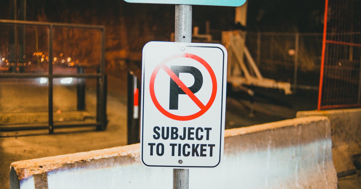 Border Control from Copenhagen (Denmark) to Malmo (Sweden) - Prohibition parking road sign with Subject To Ticket inscription placed on street of city near concrete barrier in evening time