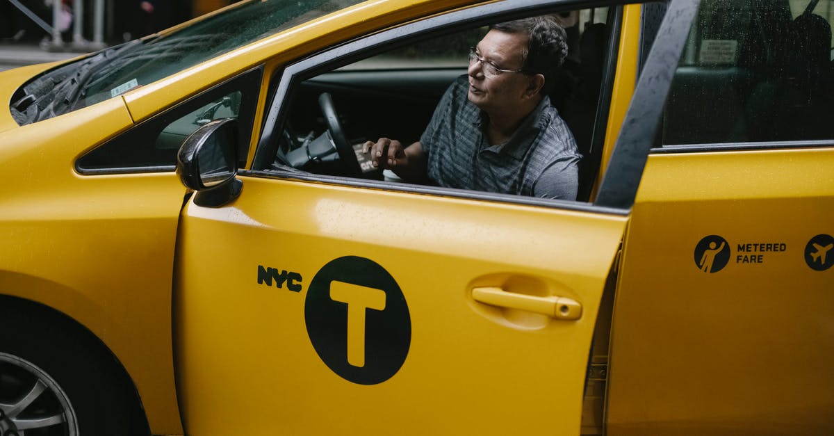 Boro cab service in New York City - Taxi driver getting out of yellow cab