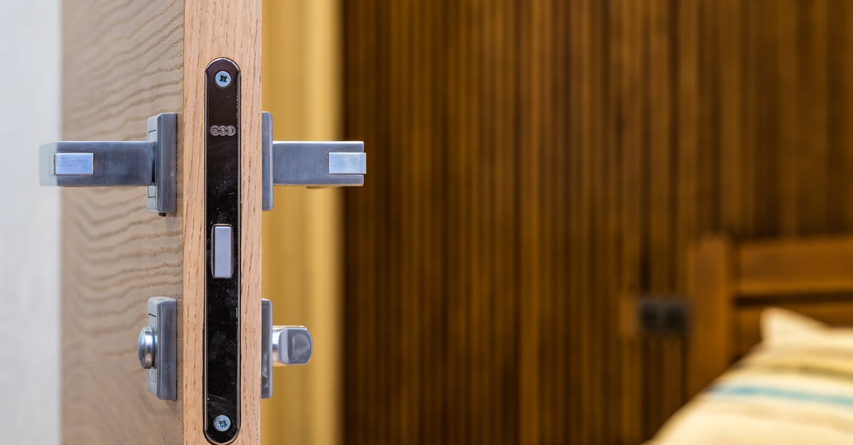 Bought new TSA suitcase, it's locked itself - how to open it? - Opened doorway with lock and simple metal handle in light room with wooden bed