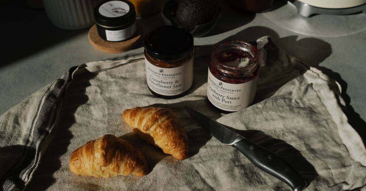Breakfast places in Munich that open at 6AM or earlier on the weekends? - Still life of delicious brown croissants with opened jam and sauce pots on gray kitchen counter placed on with fabric napkin near knife in rustic style