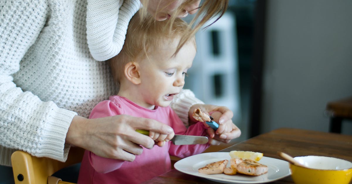 Bring baby food through TSA - A Woman Teaching a Baby Girl How to Eat