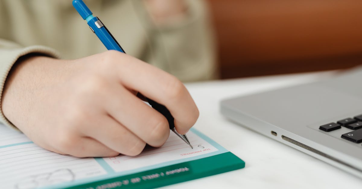 Bringing a laptop from USA to Europe - A Hand Filling Up the Form Beside the Laptop