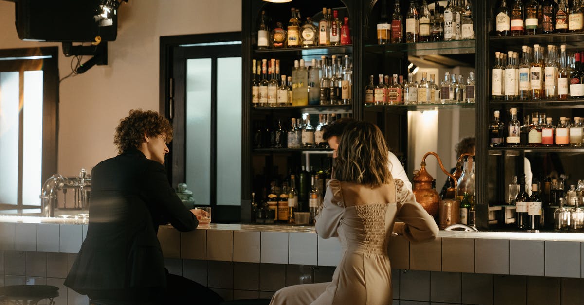 Bringing extra alcohol back to the US: what will it cost? - Man in Black Suit Jacket Standing Beside Woman in White Dress