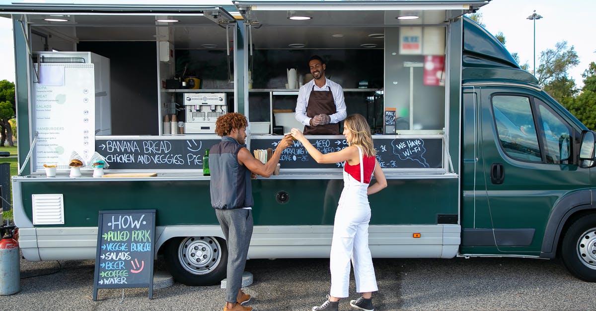 Bringing extra alcohol back to the US: what will it cost? - Diverse couple clinking beer at counter of food trailer