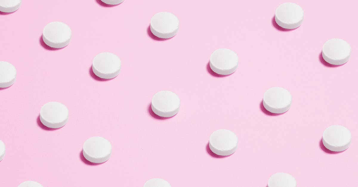 Bringing prescription drugs into Bangkok - White Round Capsule on Pink Background Close-up Photography