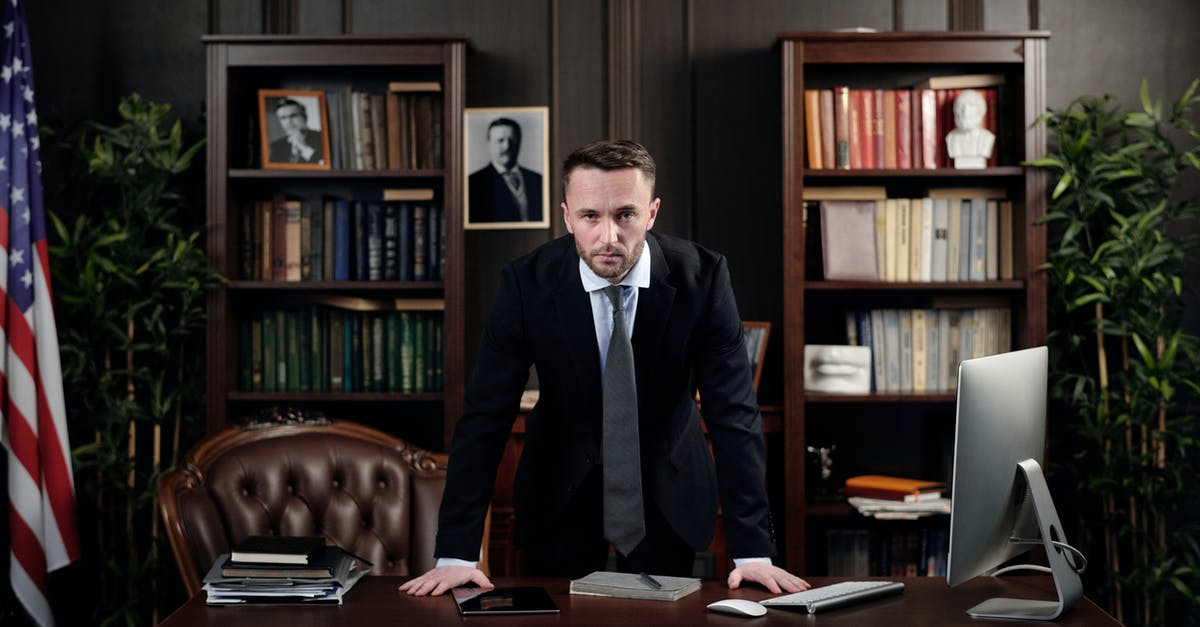 Bringing used computers/phones from USA to Romania as gifts - Businessman in his Office Looking at the Camera