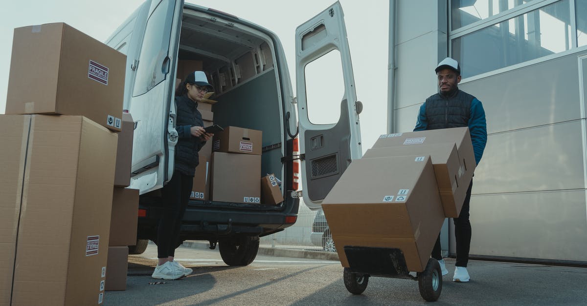 Bringing work goods across border - A Man and a Woman Working for a Delivery Company