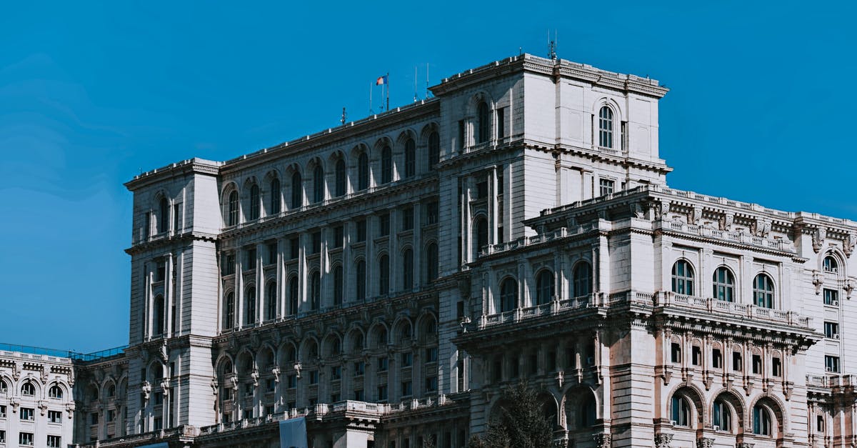 Bucharest to Sofia - Exterior of aged Palace of the Parliament with arched windows located in Bucharest against cloudless blue sky on sunny day