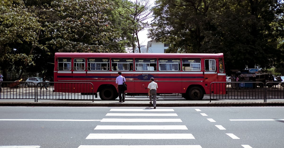 Bus 965 to Jiufen - Pedestrians Crossing the Street and a Red Bus Driving Through the Street 