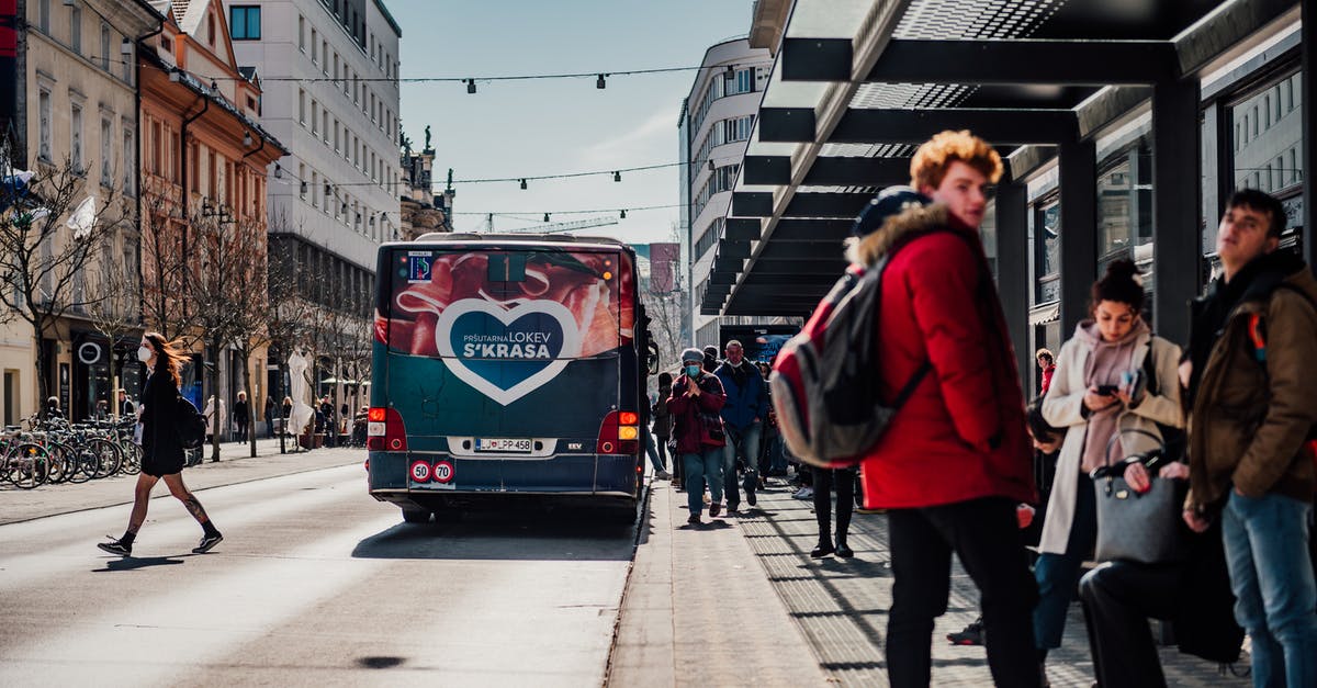 Bus schedules in Israel - Woman in Red Jacket Standing on Sidewalk