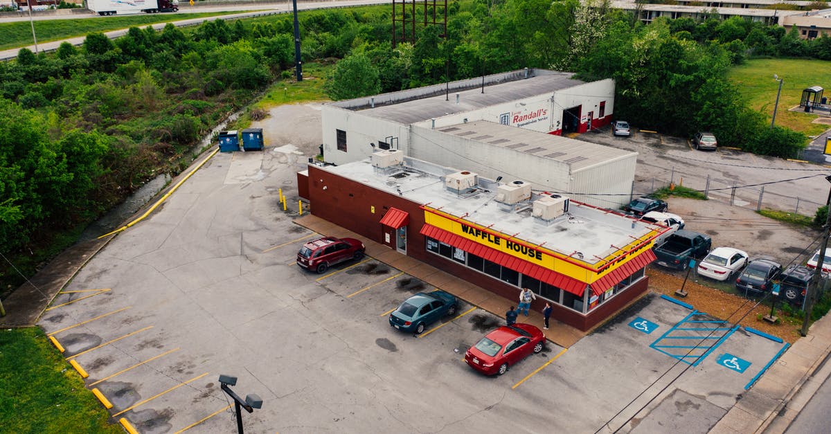 Bus service between small towns in Spain - Drone view of contemporary small street cafeteria located near busy road in suburb district