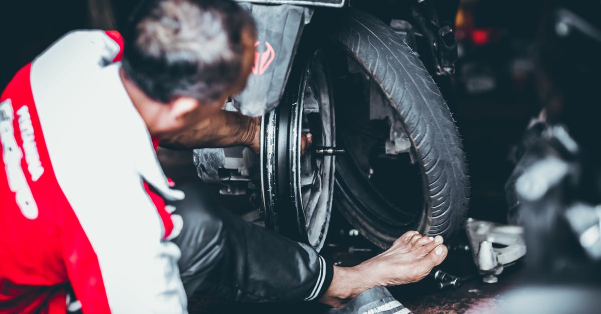 Business visit to EU for equipment installation - Man Changing a Rear Tire of a Motor Scooter