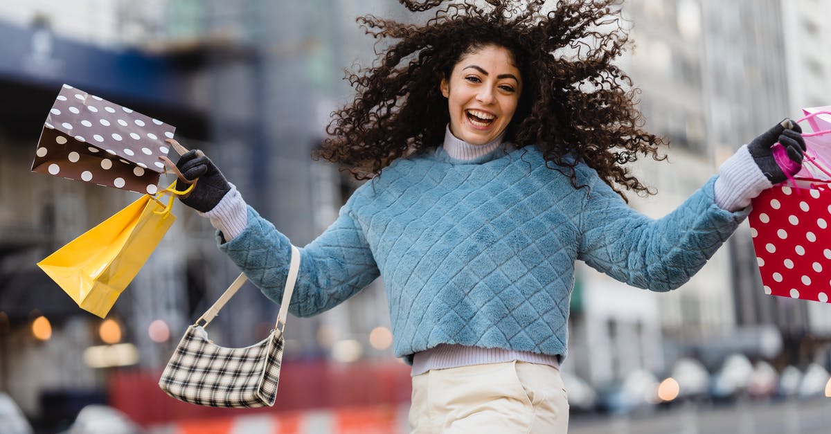 Buy alcohol duty-free or in US? - Happy woman jumping with shopping bags