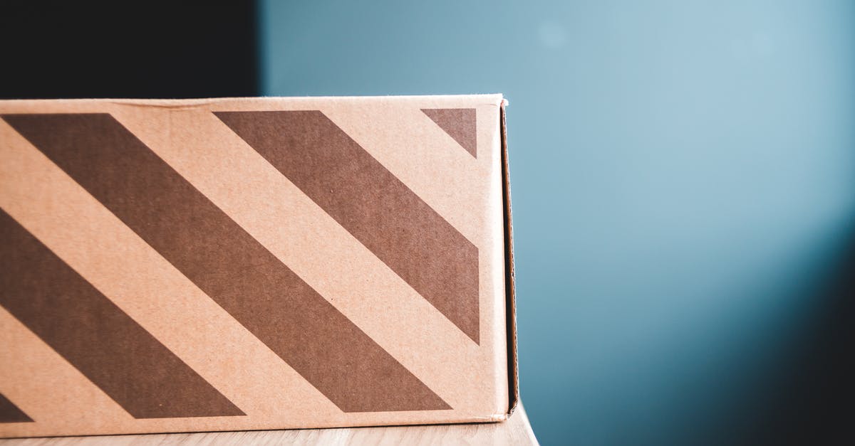 Buy and send postcard from Toluca, Mexico? - Closeup of carton box with stripes on wooden table against gray wall in apartment