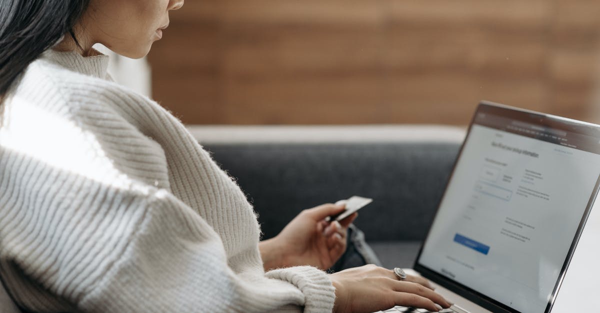 Buying a sim card in Italy - Woman in White Sweater Entering Card Details into Laptop