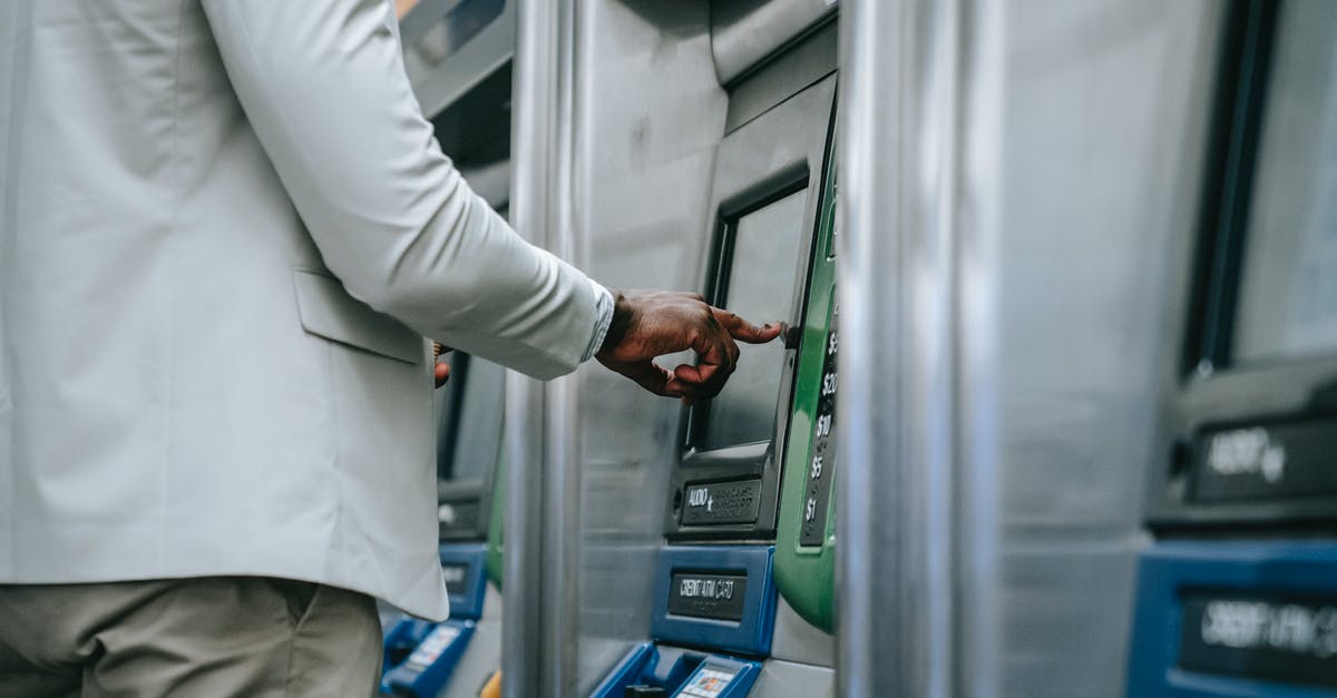 Buying air tickets for 5 people - A Person using a Ticket Machine