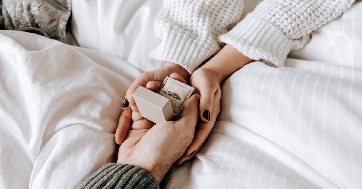 Buying an engagement ring in the US and bringing it to Australia - Crop faceless man making proposal and presenting ring to girlfriend Buying an engagement ring in the US and bringing it to Australia - Crop faceless man making proposal and presenting ring to girlfriend