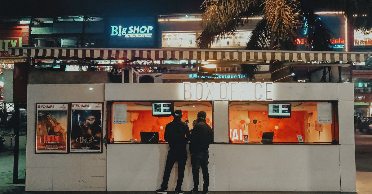 Buying plane tickets offline in Nepal - Men Buying Tickets in a Box Office 