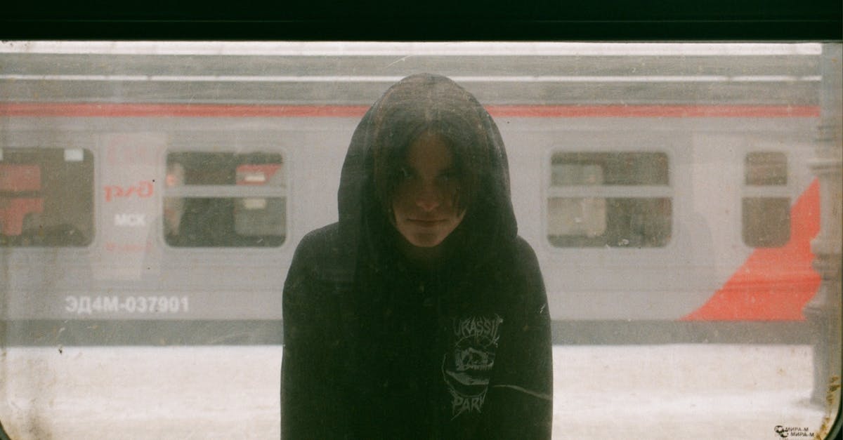 Buying ticket on Russian train - Hooded Unrecognizable Young Person Standing on Platform at Train Window